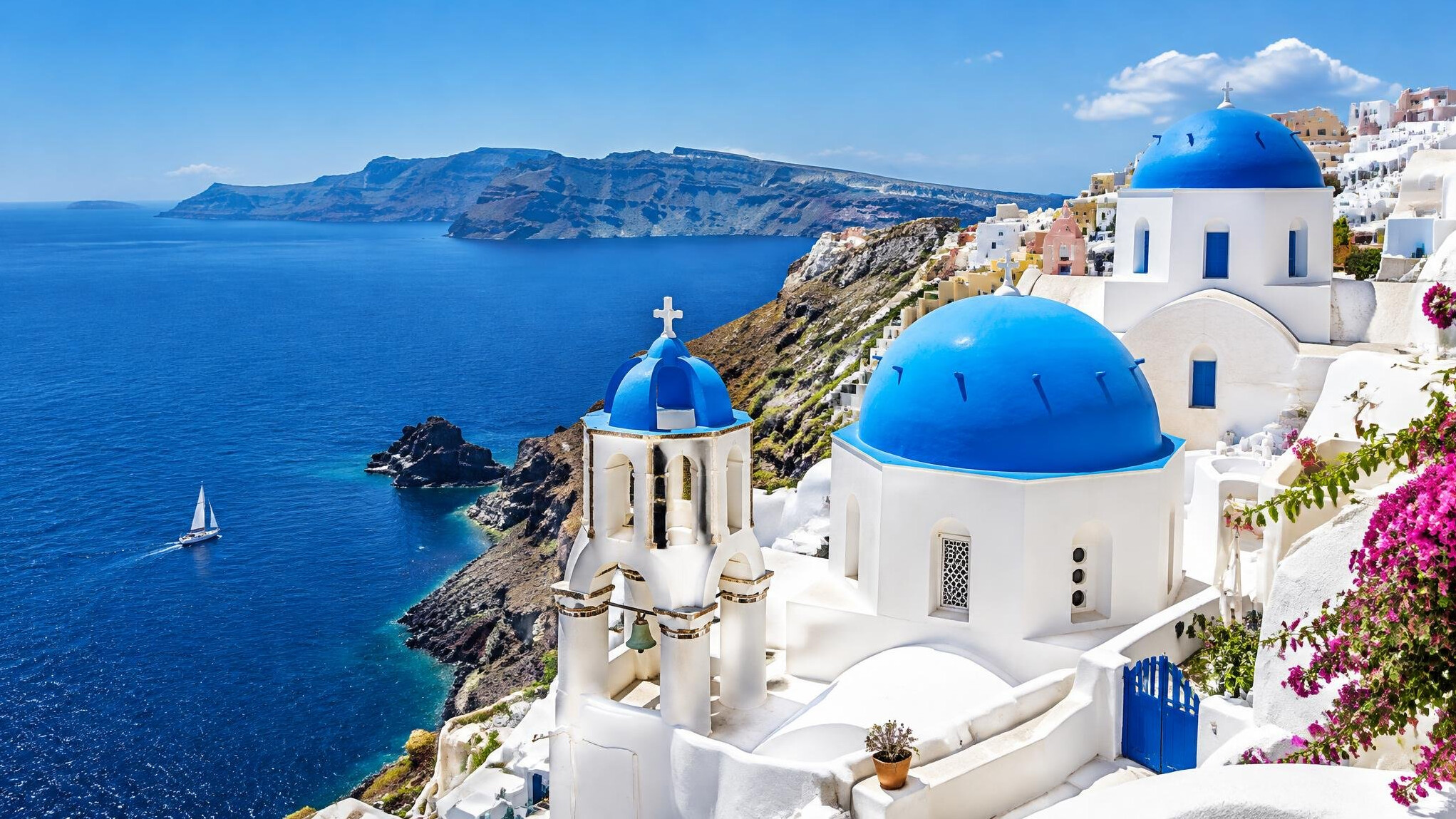 White houses with blue domes in Santorini above the sea